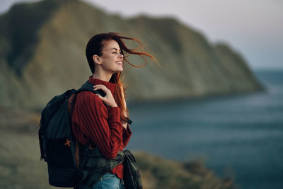 Young woman looking away while standing in sea