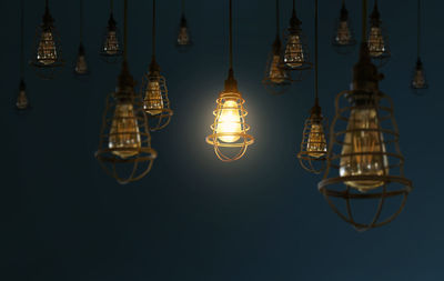 Low angle view of illuminated hanging light bulbs 