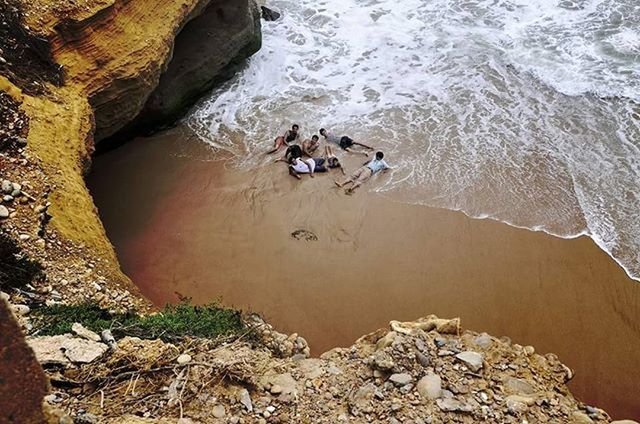 water, rock - object, high angle view, leisure activity, lifestyles, rock formation, men, sea, nature, rock, vacations, beauty in nature, person, day, sunlight, beach, shore