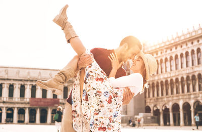 Rear view of couple kissing against the sky