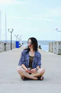 Portrait of young woman sitting on road