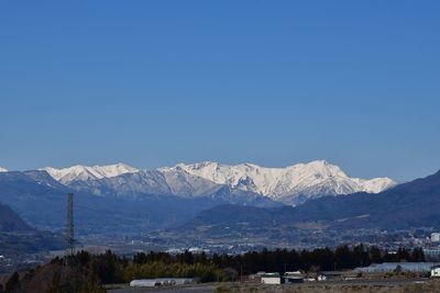 Scenic view of snowcapped mountains against clear blue sky