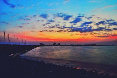 Scenic view of sea against dramatic sky during sunset