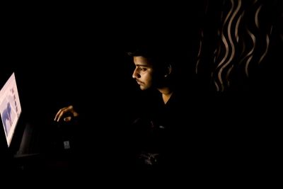 Man sitting against black background