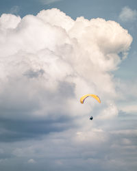 Low angle view of person paragliding against sky