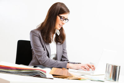 Young woman using mobile phone while sitting on table
