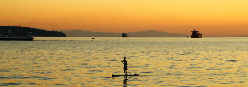 Boat sailing in sea at sunset