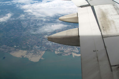 Airplane flying over water against sky