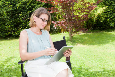 Young woman using mobile phone in park