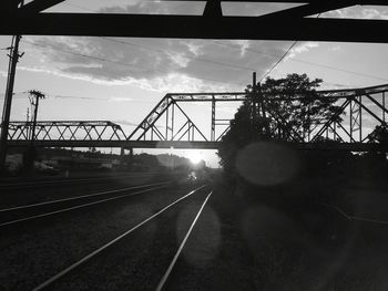 Railroad tracks by bridge against sky