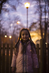 Portrait of mid adult woman against illuminated sky at sunset