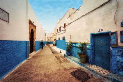 Footpath amidst buildings against sky