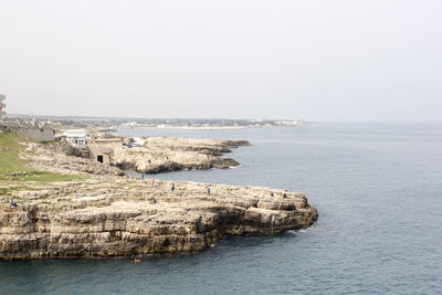 Scenic view of cliff by sea against sky