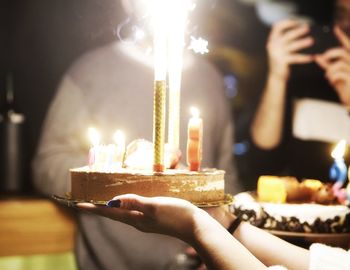 Close-up of woman holding illuminated candles