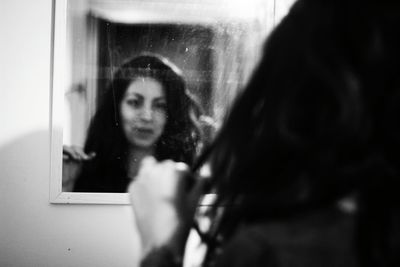 Portrait of woman looking through window