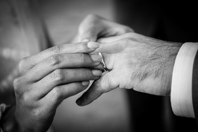 Close-up of woman putting ring on man