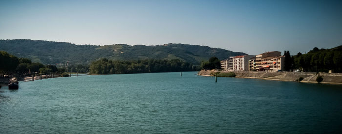 Scenic view of sea by buildings against clear sky