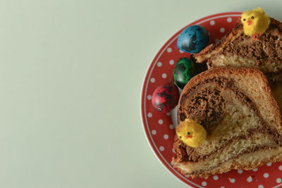 Directly above shot of easter eggs and cakes in plate on table