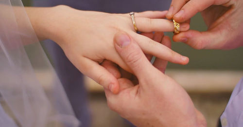 Close-up of man putting ring during wedding ceremony