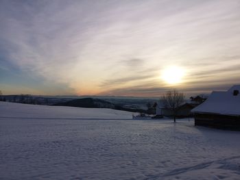 Scenic view of snow covered landscape against sky during sunset