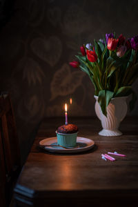 Close-up of illuminated red flower on table