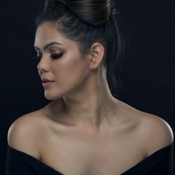 Close-up portrait of a beautiful young woman over black background