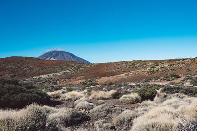 Scenic view of mountains against clear blue sky