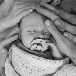 Cropped image of hands touching cute baby