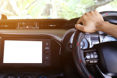 Midsection of man using smart phone in car