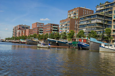 Boats in river with buildings in background