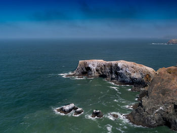 Scenic view of rocks in sea against sky