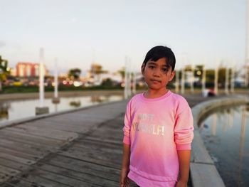 Portrait of girl standing against sky