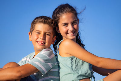 Portrait of smiling friends against clear sky