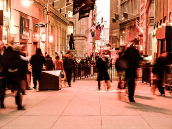 People walking on city street at night