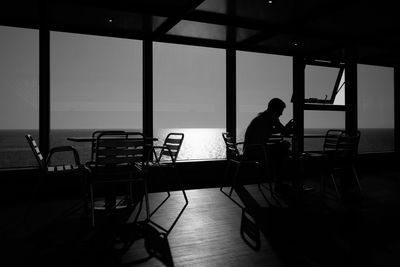 Rear view of man sitting on table