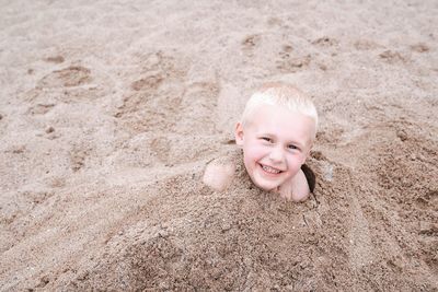 Portrait of smiling girl on sand at beach