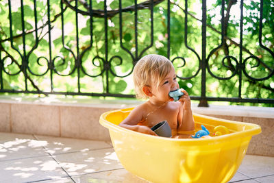 Cute boy sitting on table in bathroom