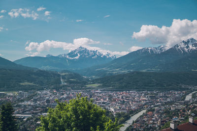 Aerial view of town by mountains against sky