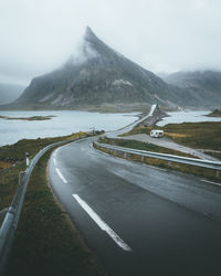 Road by mountain against sky