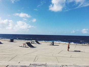 Scenic view of beach against cloudy sky