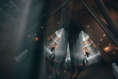 Low angle view of people walking in illuminated building