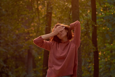 A woman in casual clothes does yoga in an old park