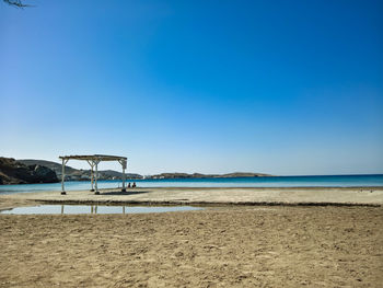 Scenic view of beach against clear blue sky