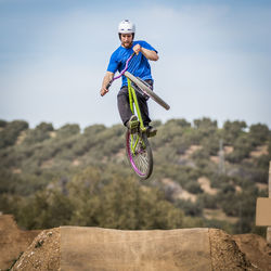 Low angle view of man jumping while doing bmx cycling