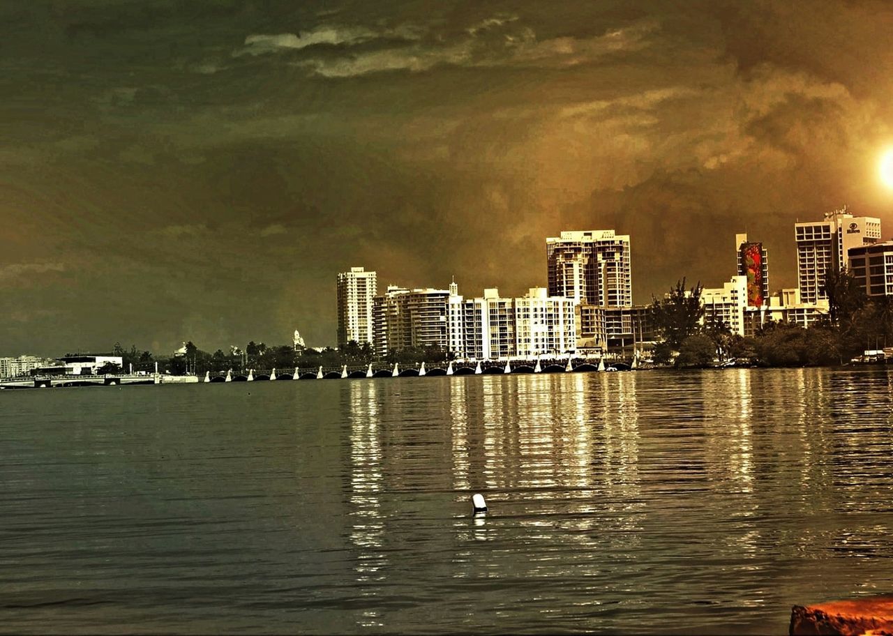building exterior, water, architecture, built structure, city, waterfront, sky, reflection, illuminated, cityscape, river, skyscraper, cloud - sky, building, urban skyline, sea, sunset, residential building, outdoors, tall - high