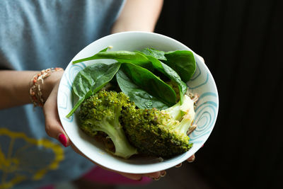 Close-up of woman holding fresh salad in bowl