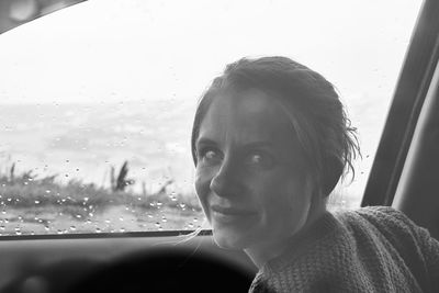 Portrait of woman looking through car window