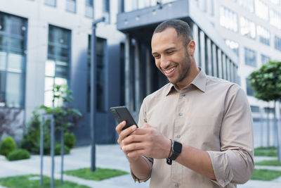 Young man using mobile phone in city