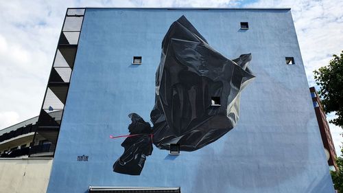 Low angle view of statue against buildings in city