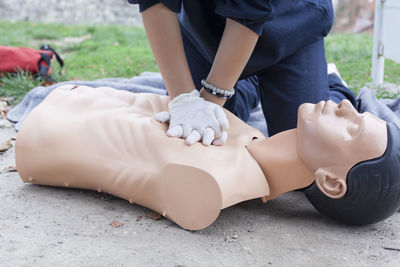 Midsection of paramedic performing cpr on mannequin